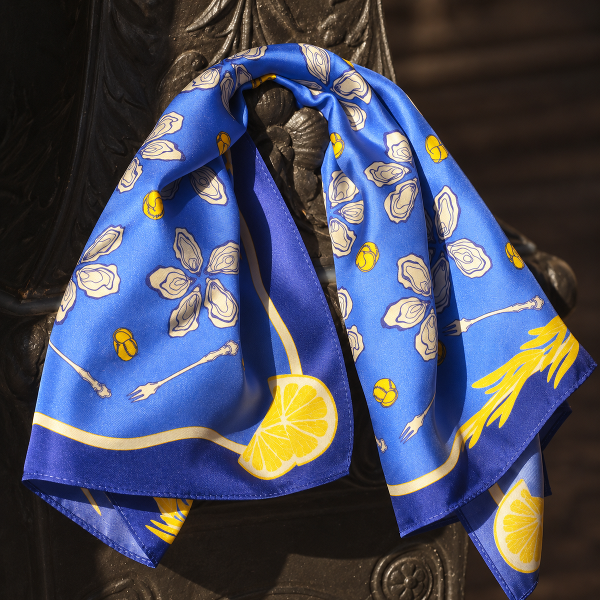 Nahaufnahme des blauen Seidentuchs Gourmet mit Austern- und Zitronenmotiven.